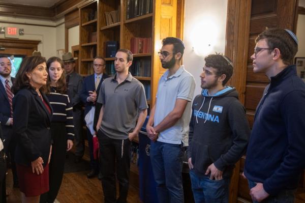 Hochul speaking with Cornell University President Martha Pollack and students at the  students at the university's Center for Jewish Living.