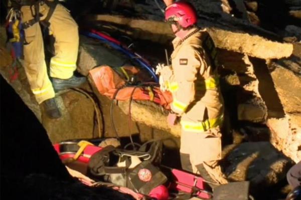 Rescuers stand on the cliff.