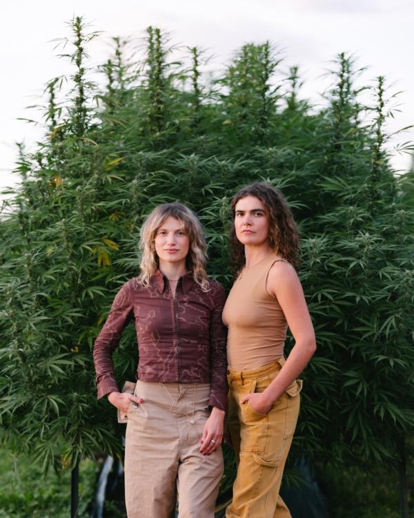 Melany and Freya Dobson standing in front of a crop of cannabis plants.