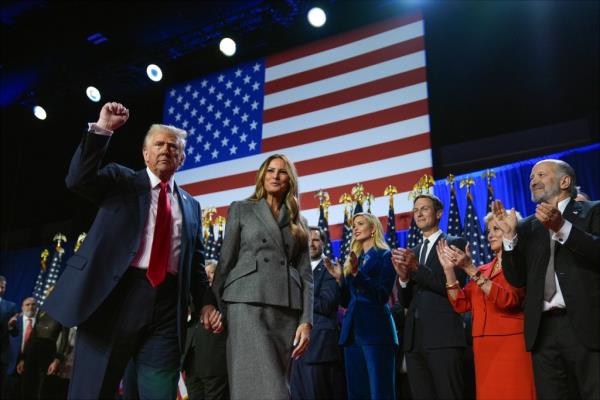 Former President Do<em></em>nald Trump and Melania Trump walking and gesturing at an election night watch party, Palm Beach Co<em></em>nvention Center, 2024.