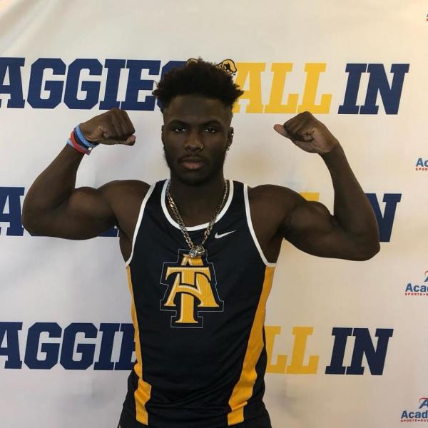 Mario Heslop flexes his biceps in an athletic tank. 