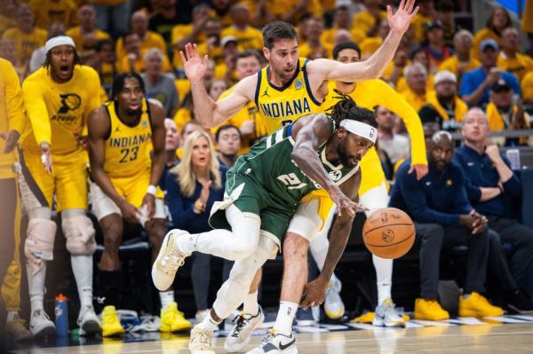 Milwaukee Bucks guard Patrick Beverley (21) dribbles the ball while Indiana Pacers guard T.J. McCo<em></em>nnell (9) defends during game six of the first round for the 2024 NBA playoffs at Gainbridge Fieldhouse.  