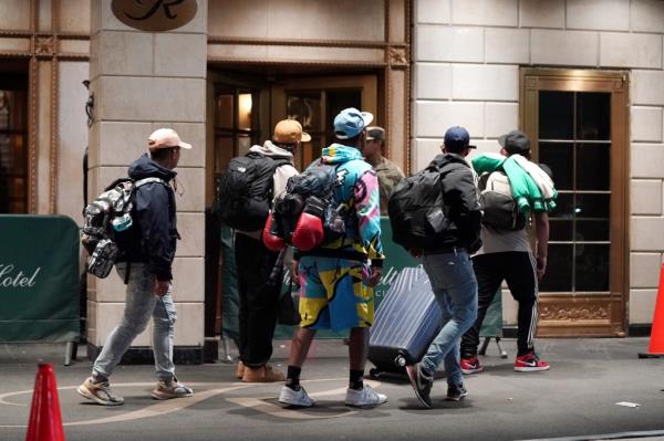 Migrants enter a hotel