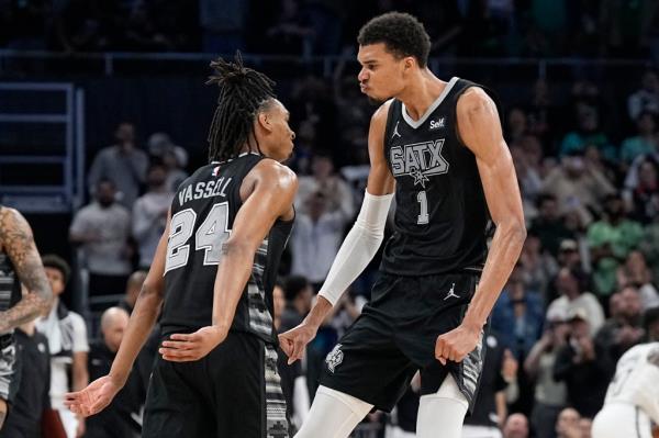 Spurs forward Victor Wembanyama (1) and guard Devin Vassell (24) react during overtime against the Nets.