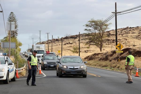 Police direct cars coming from west Maui, wher<em></em>e wildfires destroyed much of the historic town of Lahaina, 