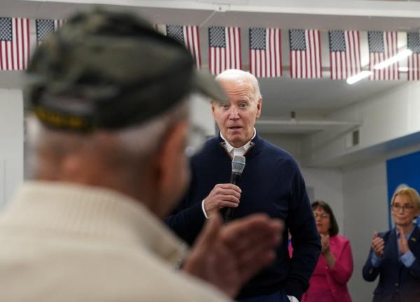 President Joe Biden speaks to a Vietnam War veteran during a visit to the campaign field office in Manchester, New Hampshire, U.S., March 11, 2024. 