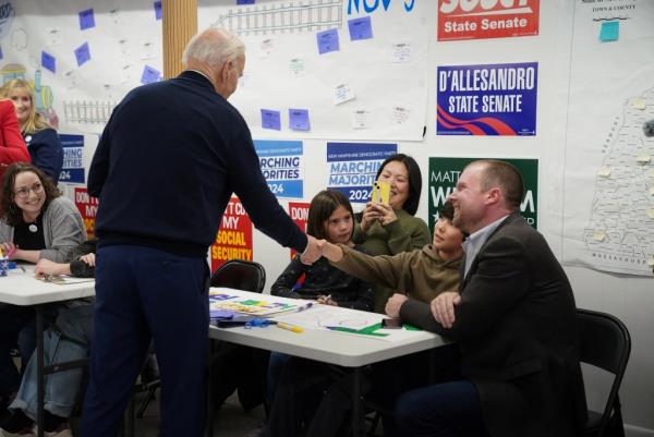 Biden greets people during a visit to his campaign field office in Manchester, New Hampshire.