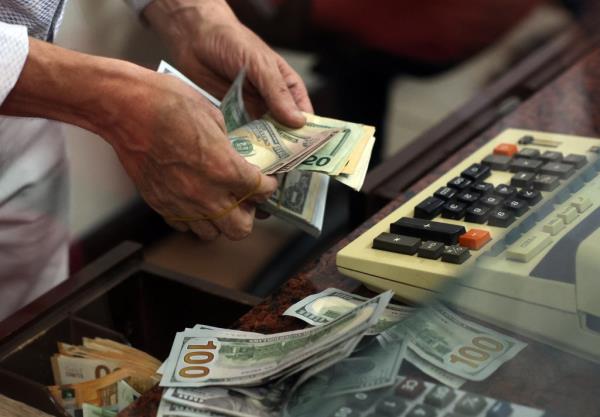A teller counting U.S. dollar bills at an exchange office in Ankara amid Turkey's slowing inflation rate in 2023.