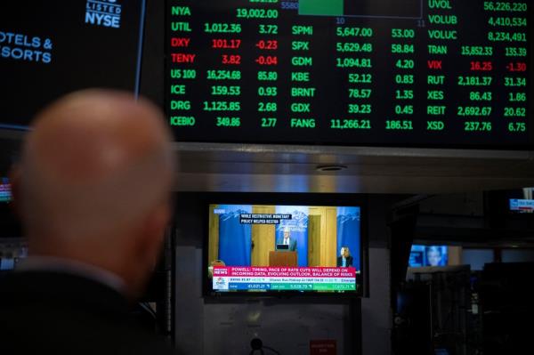 US Federal Reserve Chair Jerome Powell giving a speech a<em></em>bout cutting interest rates on a TV screen at the New York Stock Exchange.