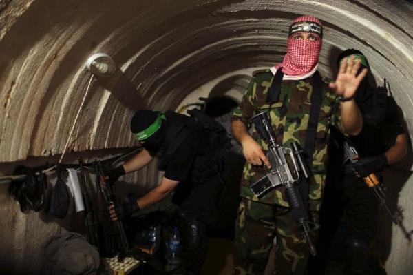 A Palestinian fighter from the Izz el-Deen al-Qassam Brigades, the armed wing of the Hamas movement, gestures inside an underground tunnel in Gaza. 
