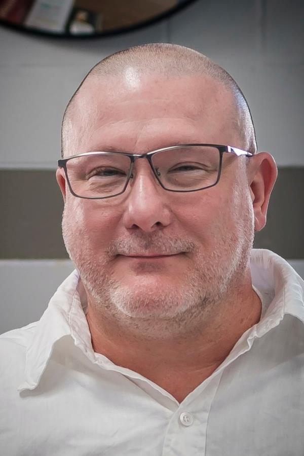 A close up of Brian Dorsey, a white, balding man with black-f<em></em>ramed glasses with a slight smile.
