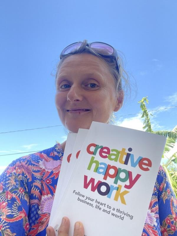 A woman with her book 'Creative Happy Work' 