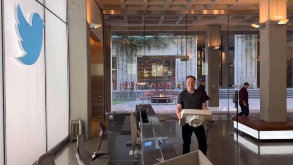 Elon Musk walking into Twitter headquarters with a kitchen sink in October 2022.