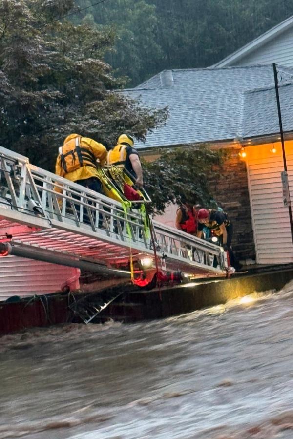 Members of Beacon Hose Co. No. 1 rescue team assisting people from the Brookside Inn in Oxford, Co<em></em>nnecticut during a flood, using a ladder
