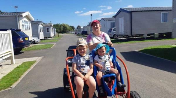 Jacob Bouyer with his two childen in a pram walking down a street