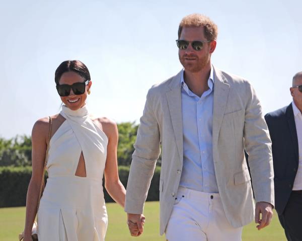 Harry and Meghan smiling in sunglasses. 
