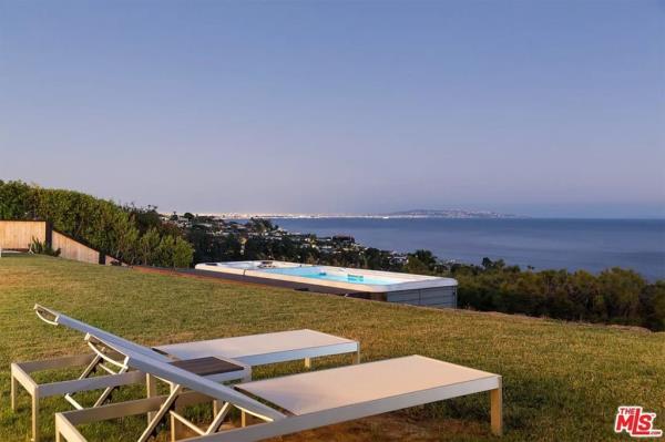 Perry had done extensive renovations to the backyard since this old listing photo was taken. The hot tub has since been expanded. 