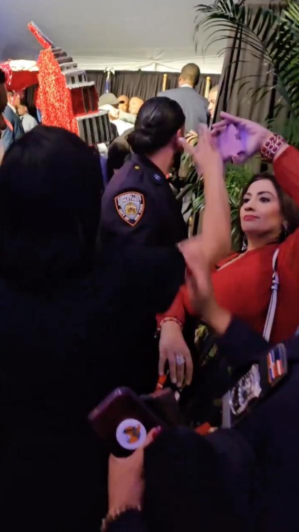 Morales grabbing a Singh's phone at Gracie Mansion as she moves back 