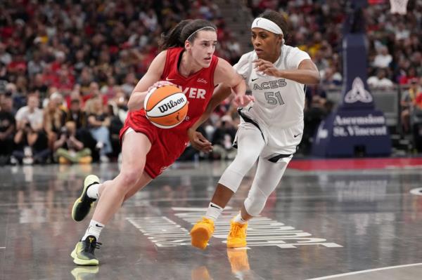 Caitlin Clark #22 of the Indiana Fever dribbles the ball while being guarded by Sydney Colson #51 of the Las Vegas Aces in the first quarter at Gainbridge Fieldhouse on September 11, 2024 