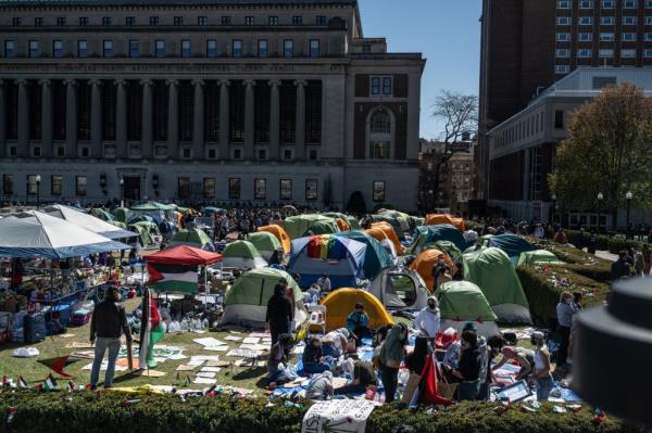 Columbia University students participating in a Pro-Palestinian protest encampment on campus, surrounded by tents.