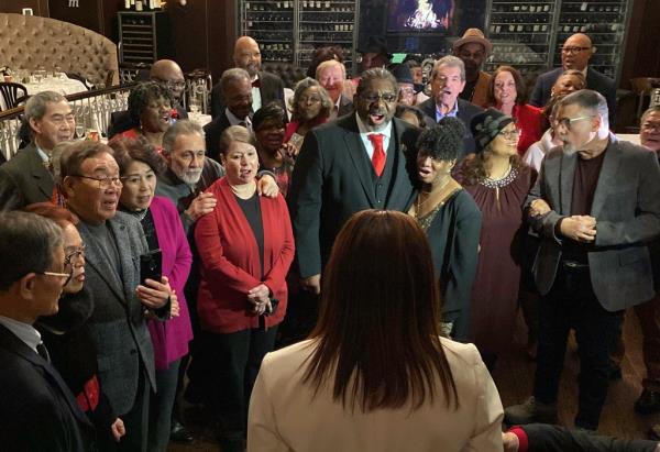 Fifty couples standing together in a room, renewing their wedding vows with Ingrid Lewis officiating in Manhattan on Valentine's Day.
