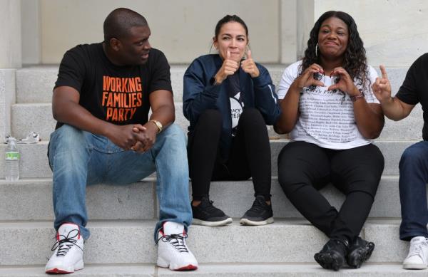 U.S. Rep. Mo<em></em>ndaire Jo<em></em>nes (D-NY) and Rep. Alexandria Ocasio-Cortez (D-NY) sit on the steps of the U.S. Capitol with Rep. Cori Bush (D-MO) 