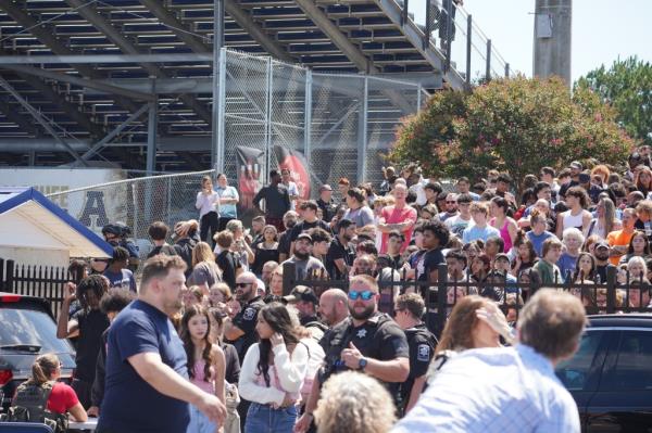 Students waiting to be picked up by their parents after being evacuated from the high school.