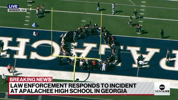 Students gathered in a prayer circle after being evacuated to the football field.