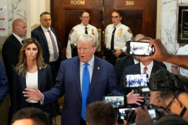 Former President Do<em></em>nald Trump (center) speaks to the media upon arriving at New York Supreme Court on Monday