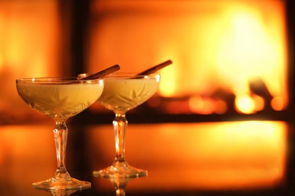 eggnog in a wine glass by a fire