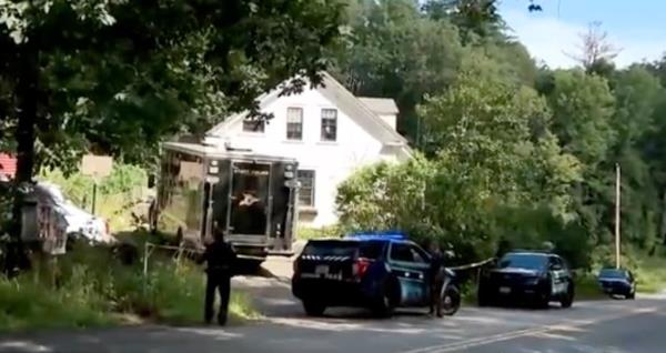 Police officers are pictured outside of a white house in New Hampshire
