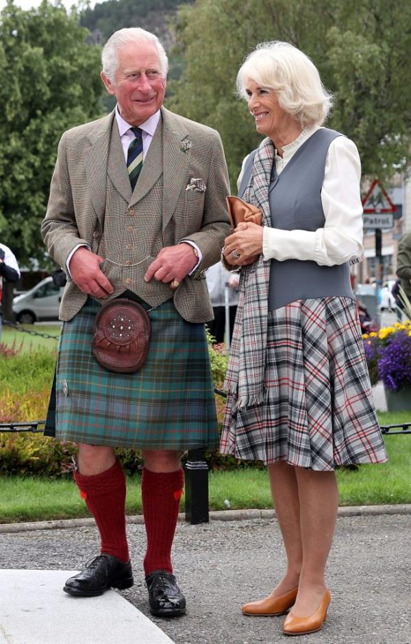 Prince Charles and Camilla, Duchess of Cornwall, walking and smiling through the village of Ballater, Scotland
