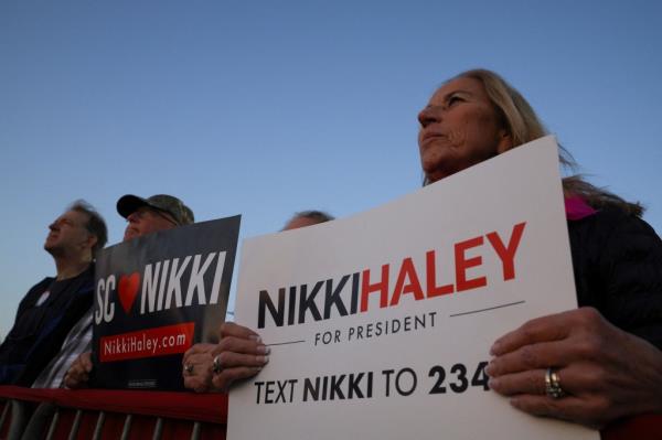 People hold signs as they wait for Republican presidential candidate and former U.S. Ambassador to the United Nations Nikki Haley to make a campaign visit ahead of the South Carolina Republican presidential primary election in Mount Pleasant, South Carolina, U.S., February 23, 2024. REUTERS/Brian Snyder</p>

<p>　　