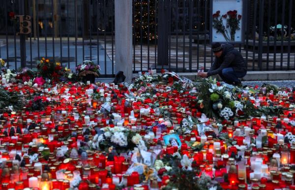 Hundreds of red candles, along with flowers and photographs, at a memorial  outside Charles University in Prague.