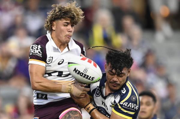 Reece Walsh co<em></em>ntests the ball with the Cowboys’ Jeremiah Nanai, despite nursing a fractured hand.