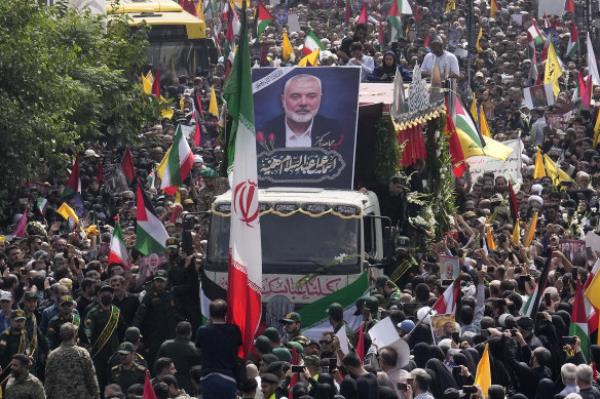 Iranians follow a truck carrying the coffins of Hamas leader Ismail Haniyeh and his bodyguard, who were killed in an assassination blamed on Israel.