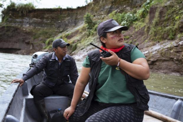 Alexandra Narváez and Holger Quenamá travel on the Aguarico River in a boat belo<em></em>nging to the Sinangoe Indigenous Guard.