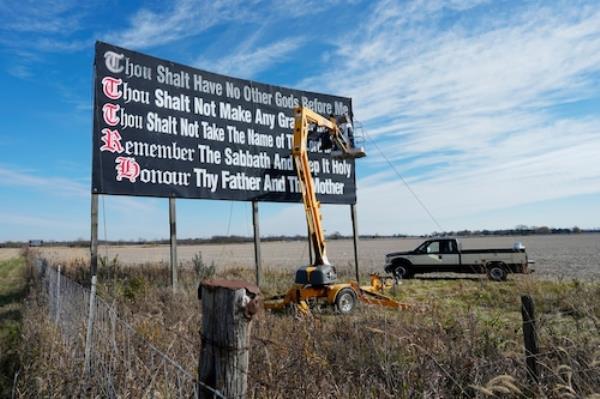 Workers repaint a Ten Commandments billboard off of Interstate 71
