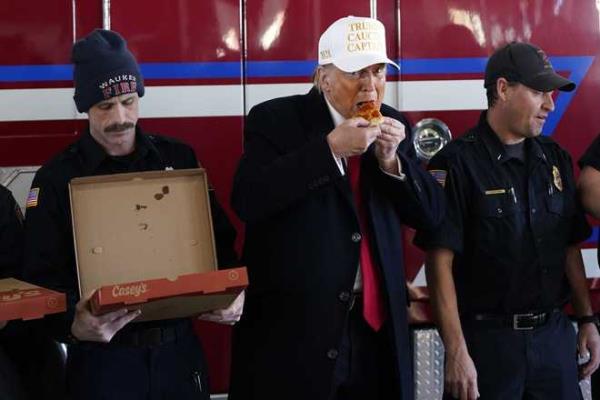 Republican presidential candidate former President Do<em></em>nald Trump eats pizza with fire fighters at Waukee Fire Department in Waukee, Iowa, Sunday, Jan. 14, 2024. (AP Photo/Andrew Harnik)